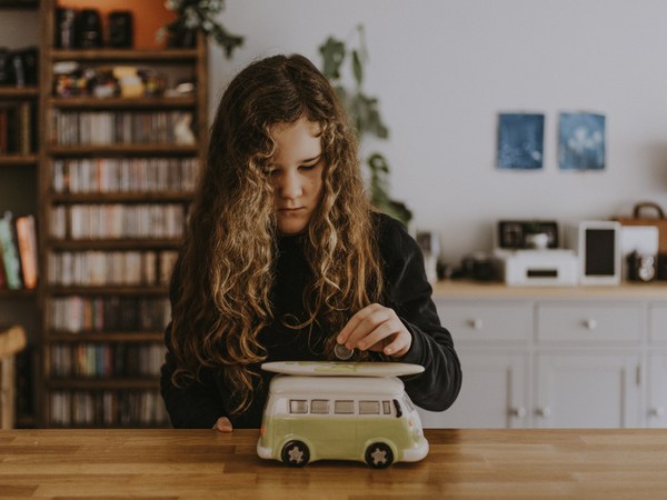 girl putting money into a money box